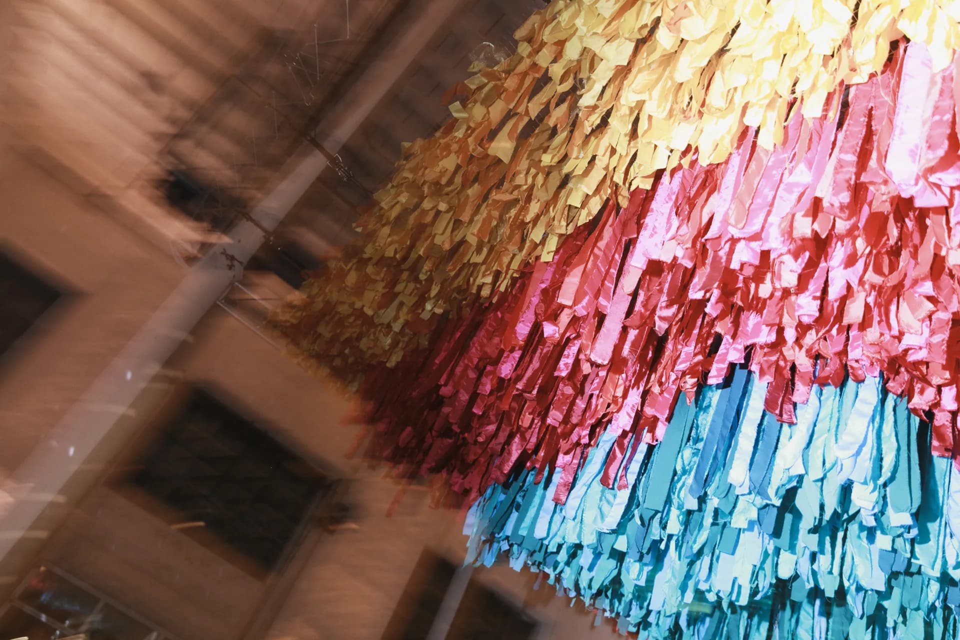 Colorful fringe installation hanging above an event space